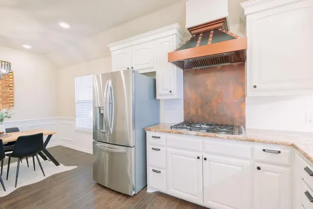 a kitchen with stainless steel appliances granite countertop a refrigerator and a stove