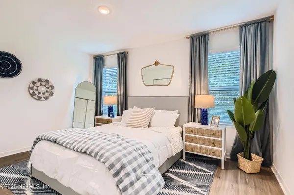 a bedroom with a bed a mirror and a window