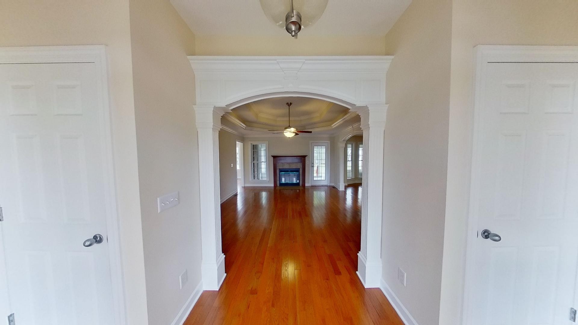 2136 Clara Mathis Road Spring Hill, TN 37174 - Photo 7 of 23 a view of a hallway to a livingroom with wooden floor and a fireplace