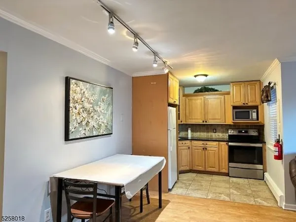 a kitchen with stainless steel appliances a stove top oven a sink a refrigerator and cabinets