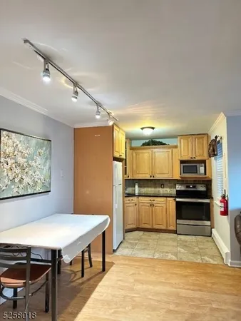 a kitchen with stainless steel appliances granite countertop a stove refrigerator and cabinets