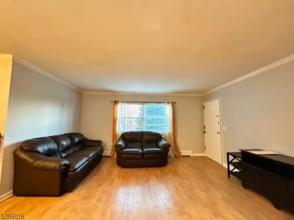 a living room with furniture a flat screen tv and a window