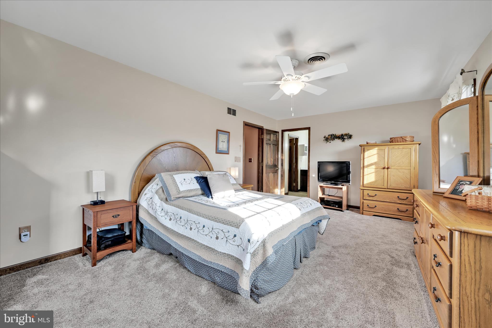 921 Acri Road Mechanicsburg, PA 17050 - Photo 16 of 46 a bedroom with a bed couch and a flat tv screen