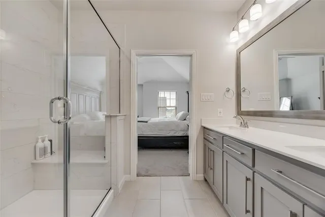 a en suite bathroom with a tub double vanity and mirrors