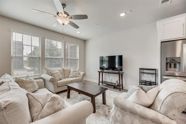 a living room with furniture a flat screen tv and a large window