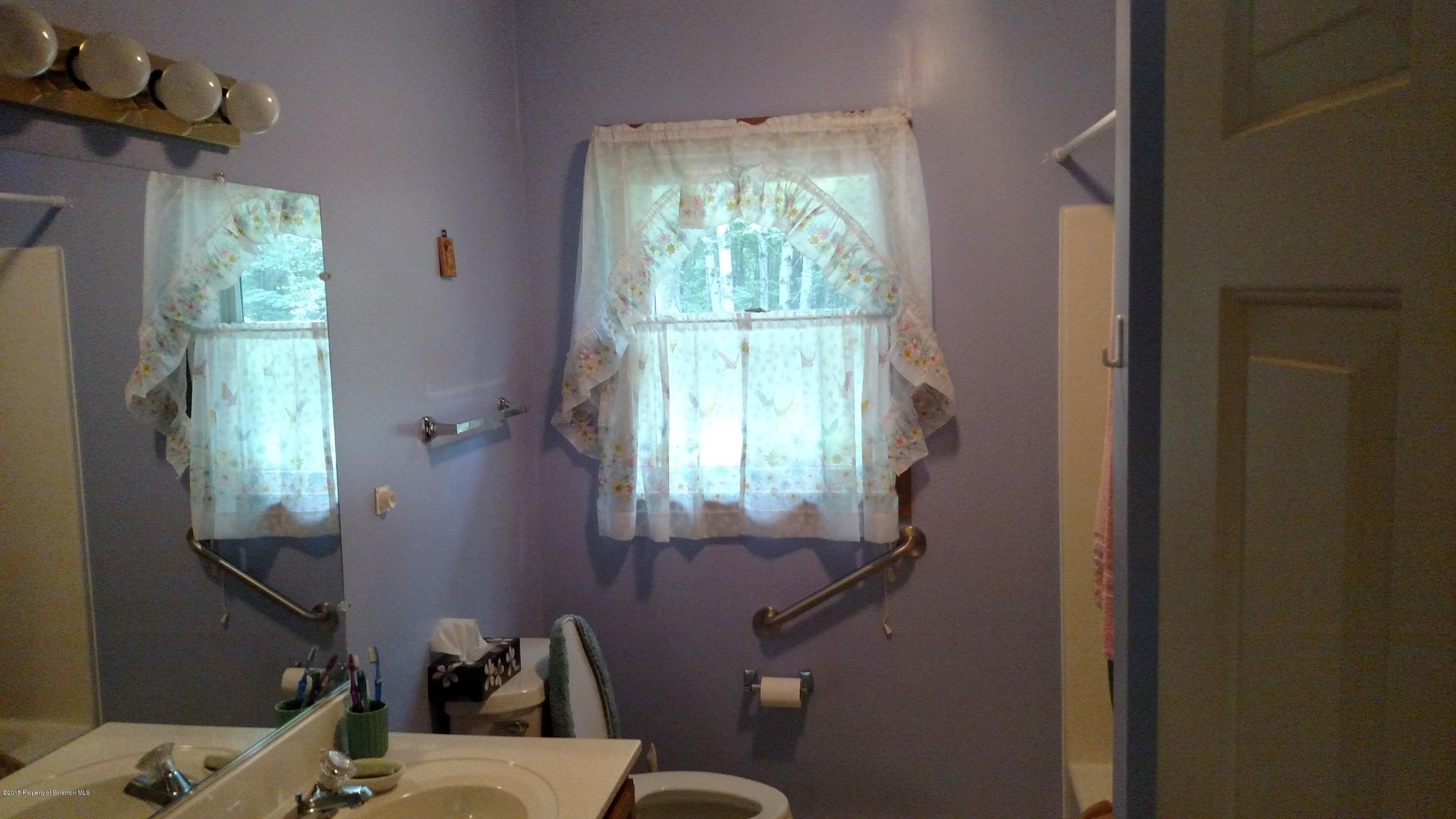 234 Hilltop Road Newfoundland, PA 18445 - Photo 8 of 21 a bathroom with a sink mirror vanity and toilet