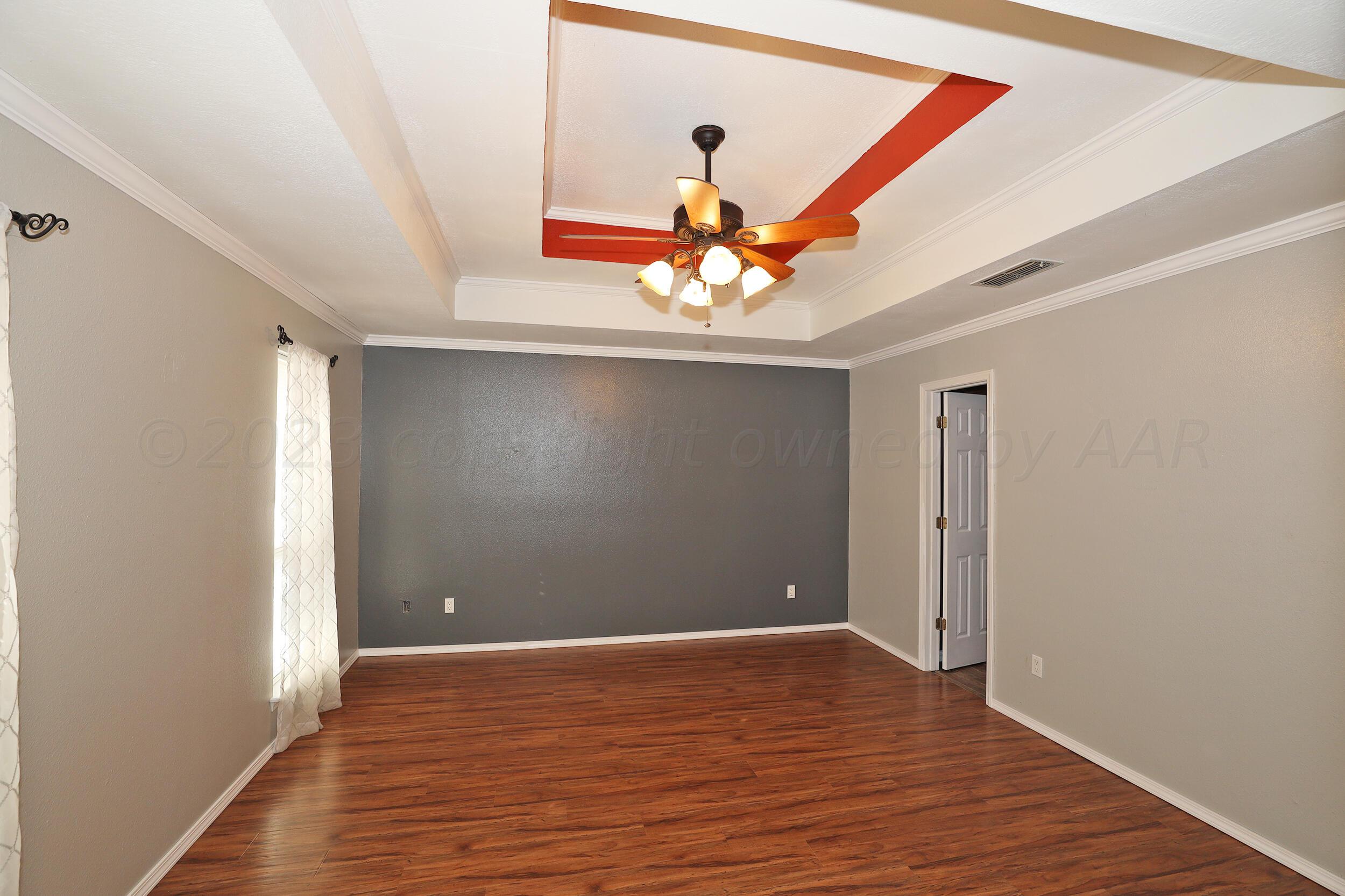 4207 Rincon Avenue Amarillo, TX 79110 - Photo 12 of 26 a view of an empty room with a window and wooden floor
