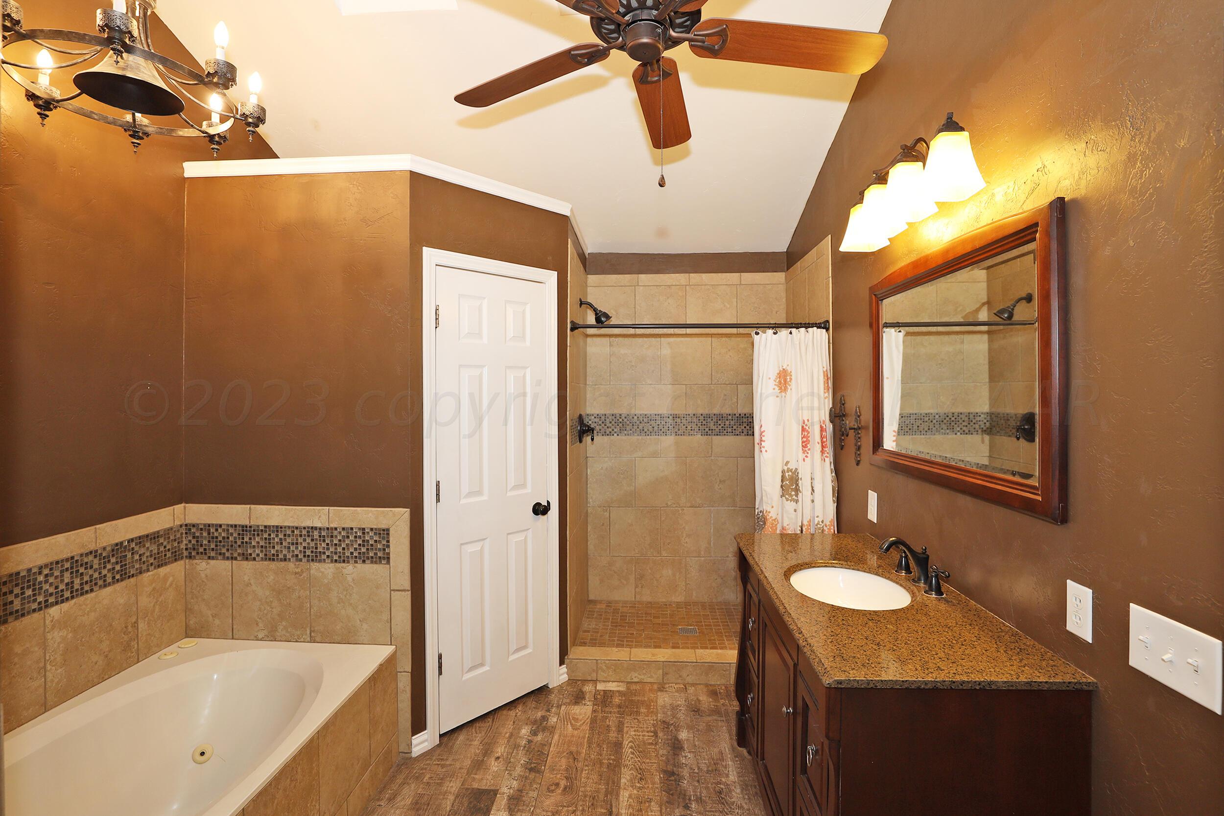 4207 Rincon Avenue Amarillo, TX 79110 - Photo 14 of 26 a bathroom with a granite countertop sink mirror vanity and bathtub