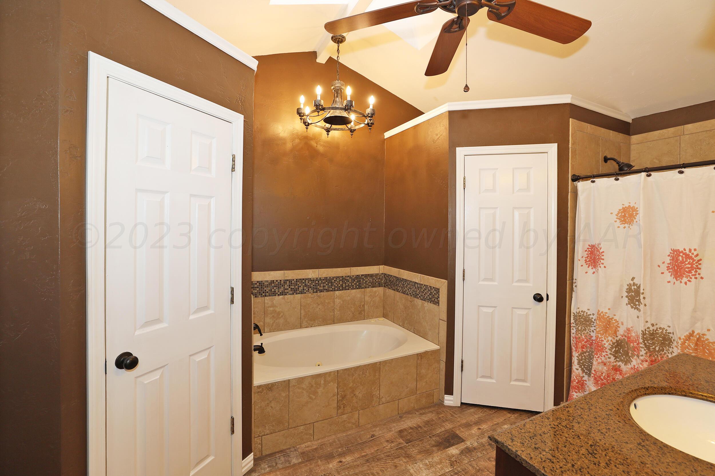 4207 Rincon Avenue Amarillo, TX 79110 - Photo 15 of 26 a bathroom with a tub and shower
