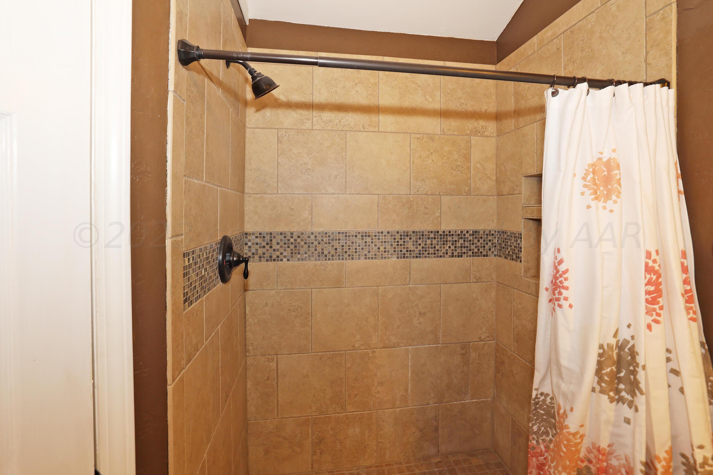 4207 Rincon Avenue Amarillo, TX 79110 - Photo 16 of 26 a bathroom with a shower and a mirror