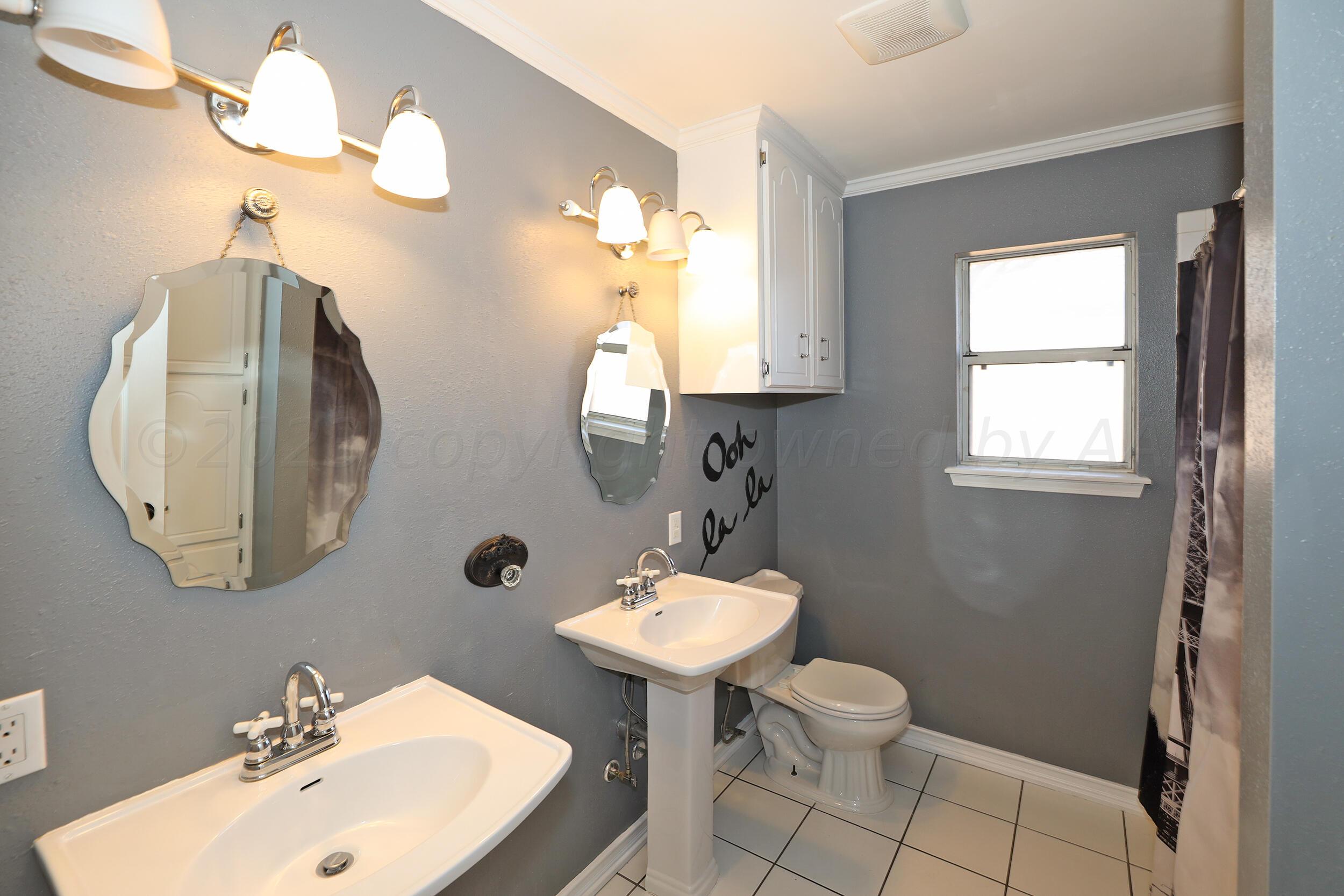 4207 Rincon Avenue Amarillo, TX 79110 - Photo 21 of 26 a bathroom with a toilet sink and mirror