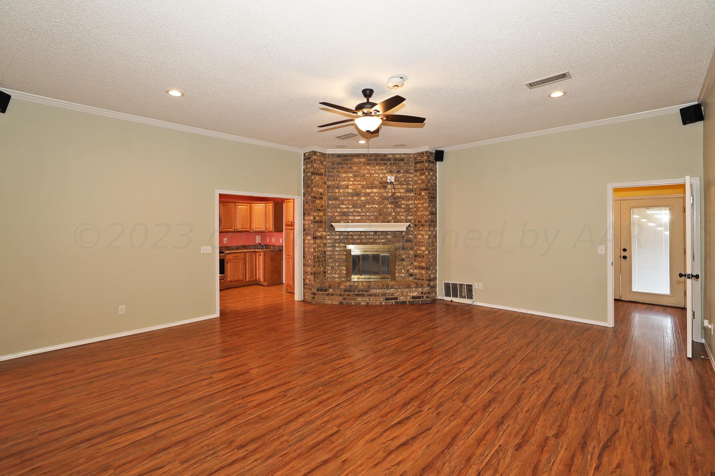 4207 Rincon Avenue Amarillo, TX 79110 - Photo 4 of 26 a view of an empty room with a window and wooden floor