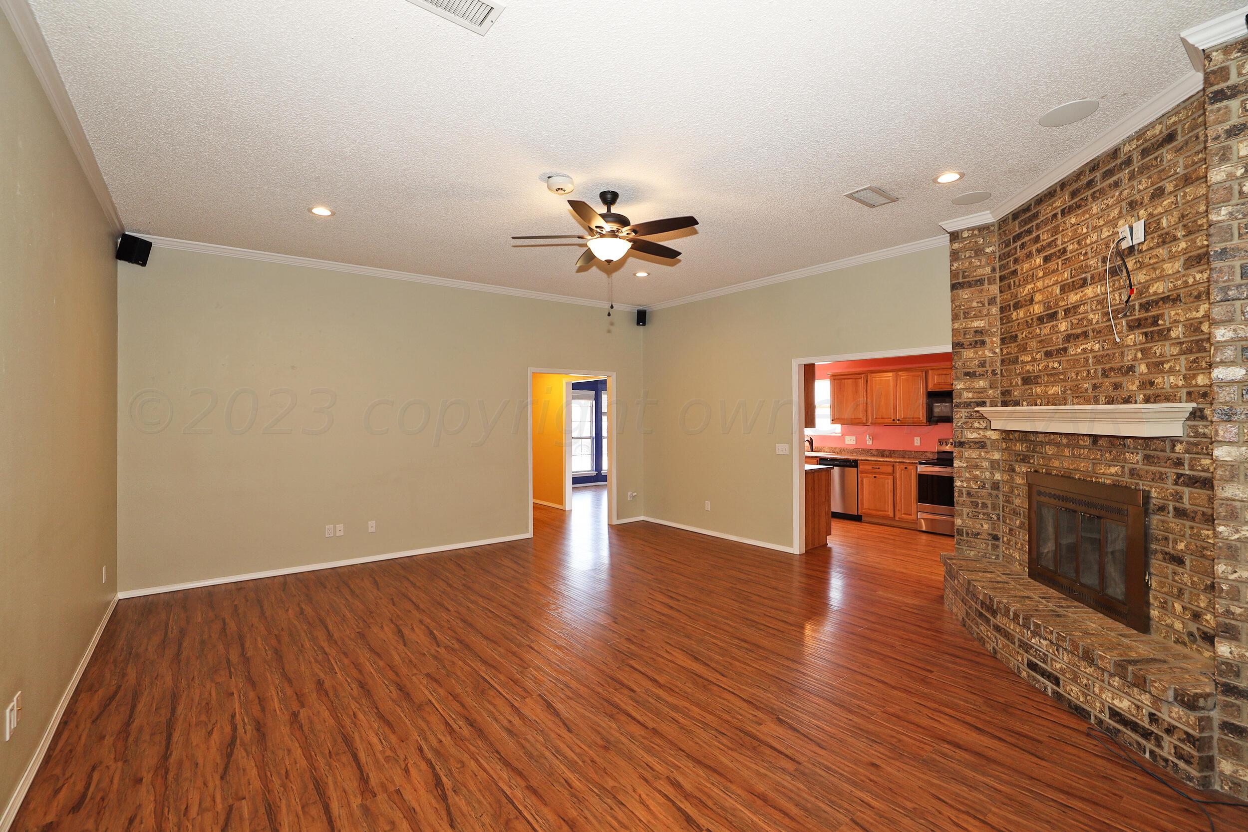 4207 Rincon Avenue Amarillo, TX 79110 - Photo 5 of 26 wooden floor in an empty room with a fireplace