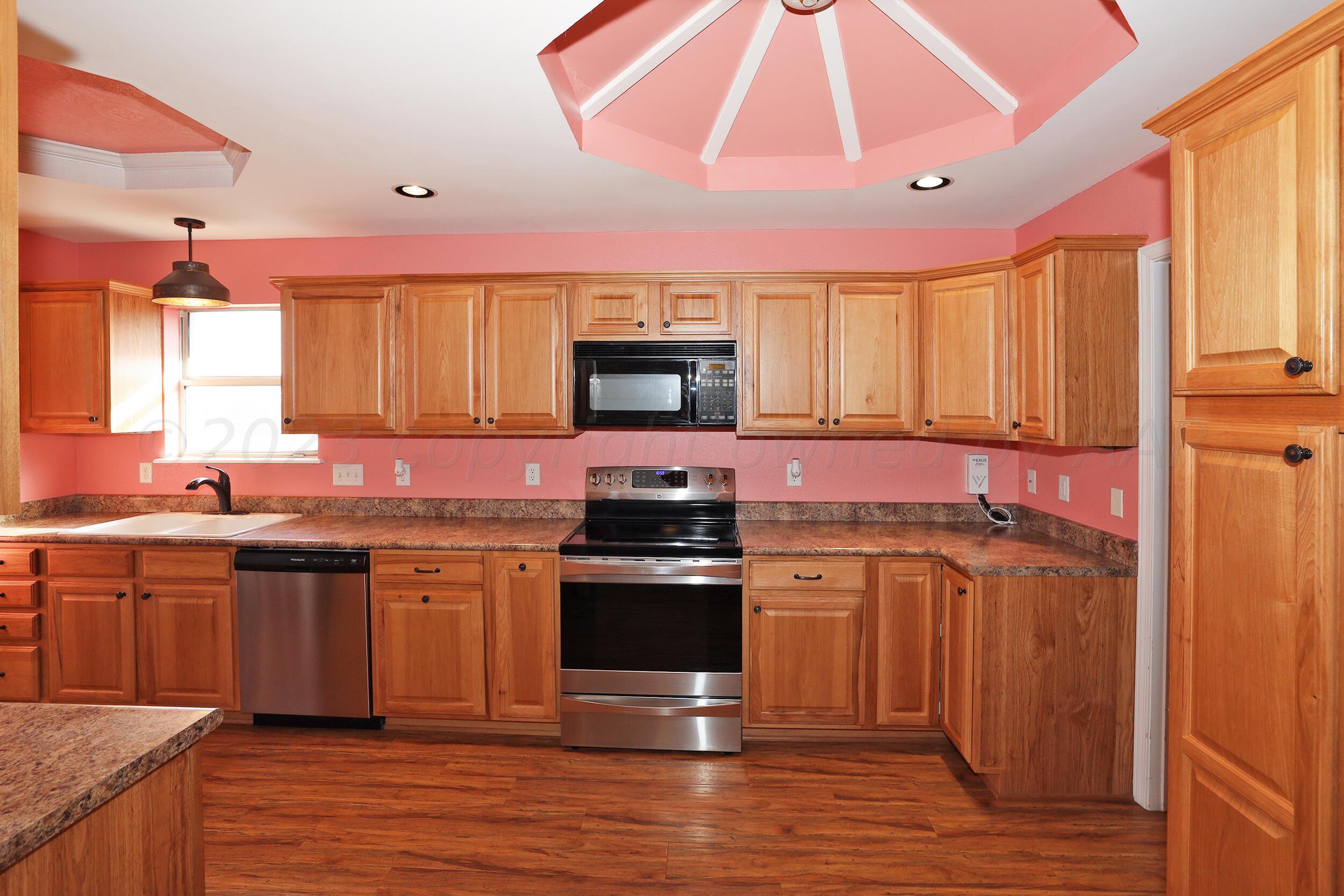 4207 Rincon Avenue Amarillo, TX 79110 - Photo 8 of 26 a kitchen with stainless steel appliances a stove a sink cabinets and a wooden floor