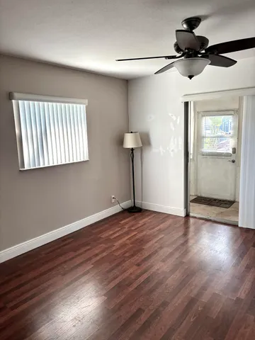 a view of a livingroom with wooden floor and a ceiling fan