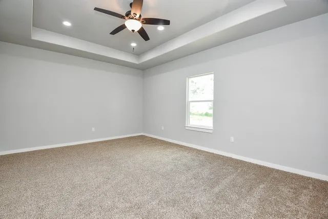 an empty room with a window and a fan
