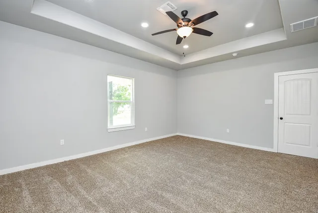 an empty room with a window and a fan