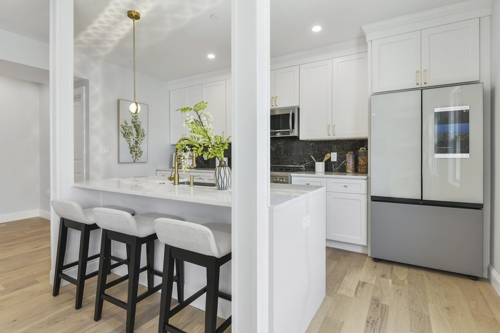 a kitchen with a table chairs refrigerator and microwave
