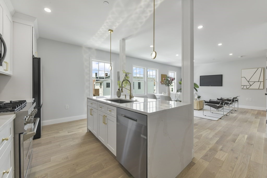 137 Falcon Street, Unit 2 Boston, MA 02128 - Photo 2 of 4 a large kitchen with kitchen island granite countertop a large counter top stainless steel appliances and cabinets