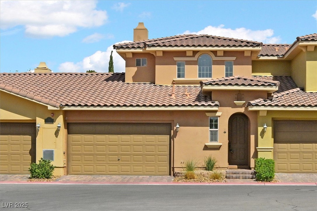 31 Via Mantova, Unit 2 Henderson, NV 89011 - Photo 1 of 30 Mediterranean / spanish home featuring a chimney, stucco siding, driveway, and a tile roof