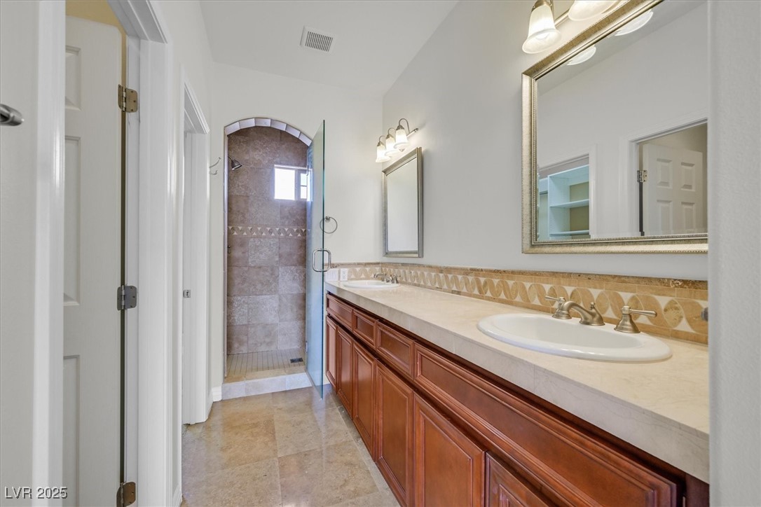 31 Via Mantova, Unit 2 Henderson, NV 89011 - Photo 12 of 30 Full bath with a shower stall, double vanity, and light tile patterned flooring