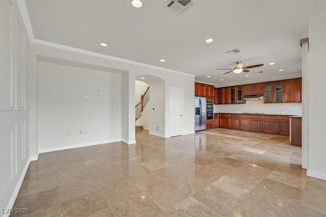 31 Via Mantova, Unit 2 Henderson, NV 89011 - Photo 3 of 30 Unfurnished living room with arched walkways, crown molding, recessed lighting, ceiling fan, and stairway
