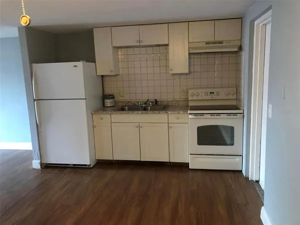 a white kitchen with a stove top oven