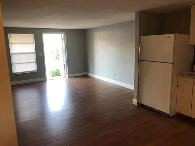 a view of a kitchen with wooden floor and a refrigerator