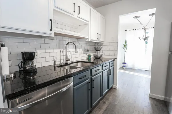 a kitchen with stainless steel appliances a sink stove and cabinets