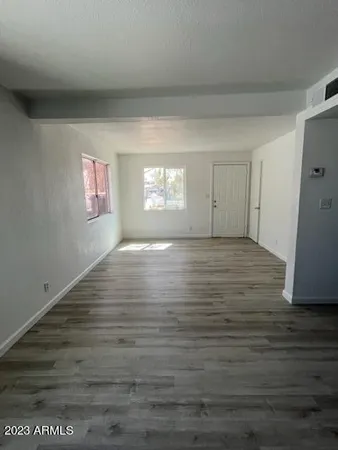 a view of empty room with window and wooden floor