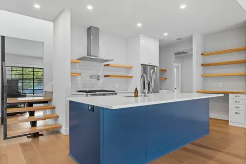 a kitchen with stainless steel appliances a sink stove and cabinets
