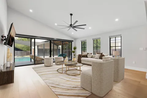 a living room with fireplace furniture and a large window