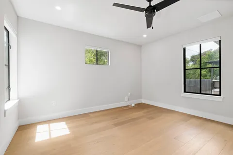 an empty room with fan and windows