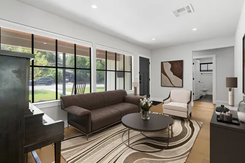 a living room with furniture and a floor to ceiling window