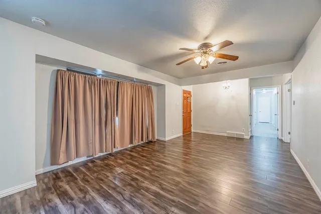 a view of a room with wooden floor and a ceiling fan