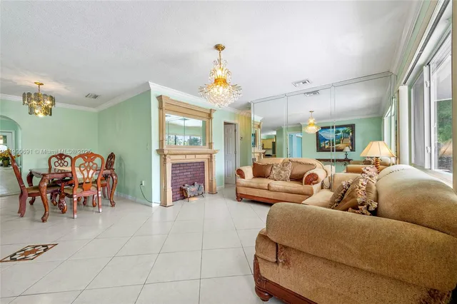 a living room with furniture a fireplace and a chandelier