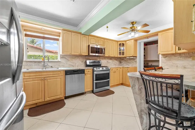a kitchen with stainless steel appliances granite countertop a stove top oven a sink dishwasher and a refrigerator