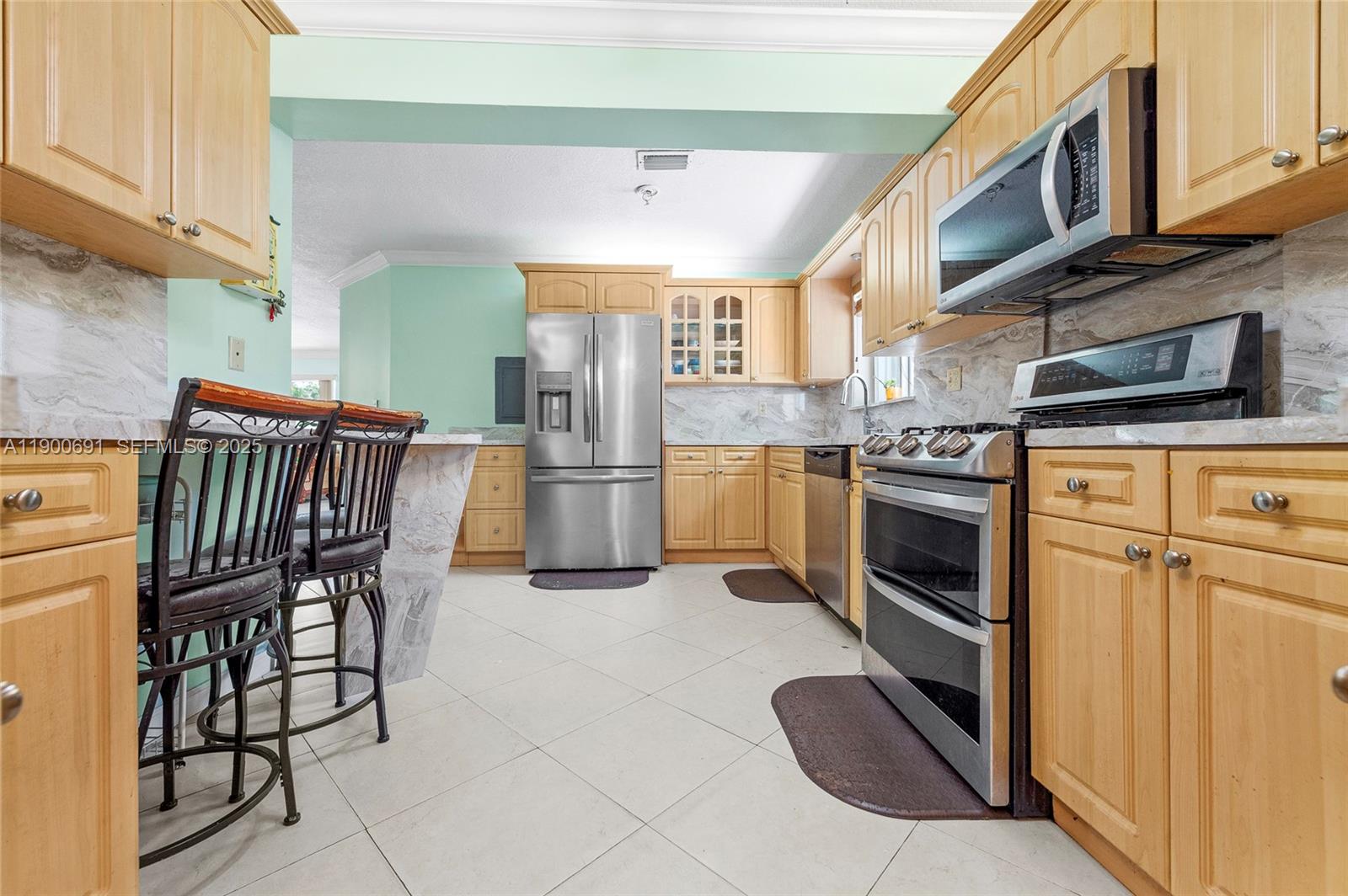 7311 Southwest 139th Avenue Miami, FL 33183 - Photo 23 of 37 a kitchen with stainless steel appliances granite countertop a stove a sink dishwasher and a refrigerator with wooden cabinets