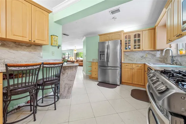 a kitchen with granite countertop a stove a sink dishwasher a refrigerator and cabinets with wooden floor