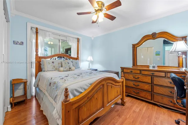 a bedroom with a bed and a dresser with wooden floor