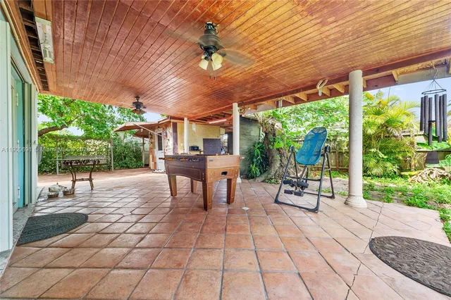 a view of a patio with a table and chairs under an umbrella