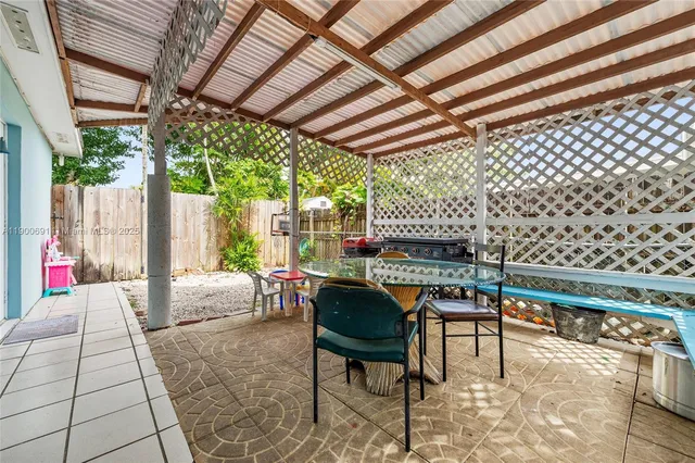 a patio with table and chairs and potted plants