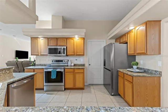 a large kitchen with stainless steel appliances granite countertop a sink and stove