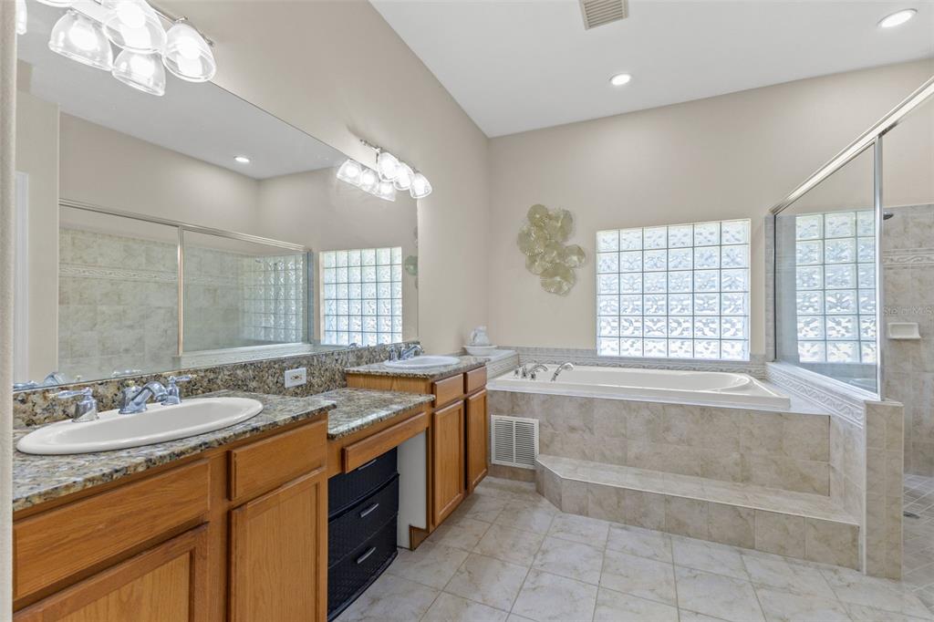 14071 Linden Drive Spring Hill, FL 34609 - Photo 30 of 77 a spacious bathroom with a granite countertop sink and a bathtub