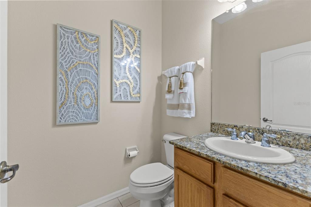 14071 Linden Drive Spring Hill, FL 34609 - Photo 33 of 77 a bathroom with a granite countertop sink toilet and a mirror