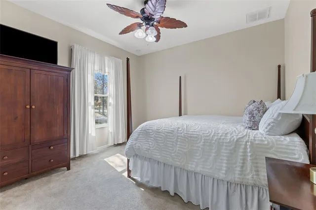 a living room with furniture a flat screen tv and a floor to ceiling window