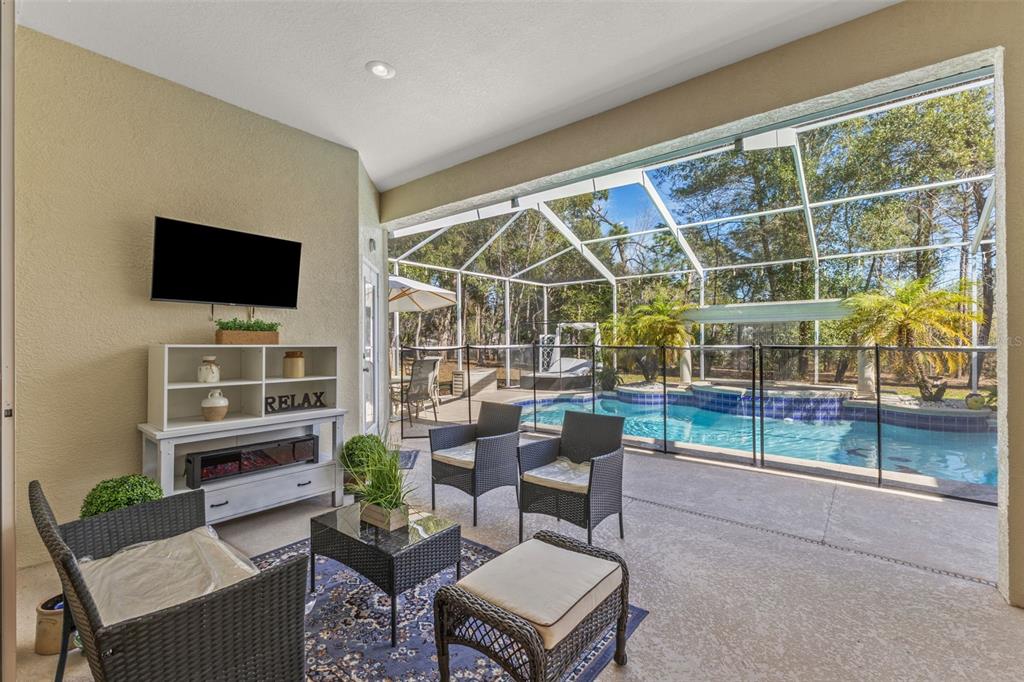 14071 Linden Drive Spring Hill, FL 34609 - Photo 44 of 77 a living room with furniture a flat screen tv and a floor to ceiling window