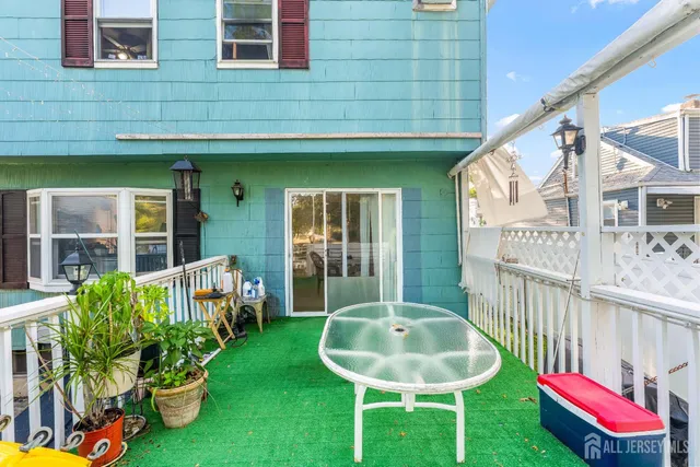 a front view of a house with a chairs and table in a patio