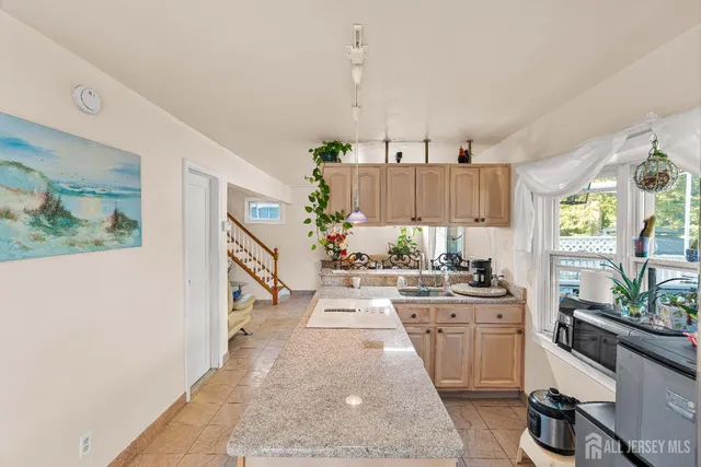 a kitchen with granite countertop a stove a sink and a refrigerator