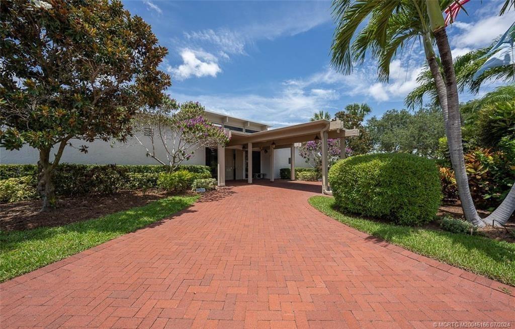 1950 Southwest Palm City Road, Unit 14302 Stuart, FL 34994 - Photo 45 of 62 a front view of a house with a garden and a tree